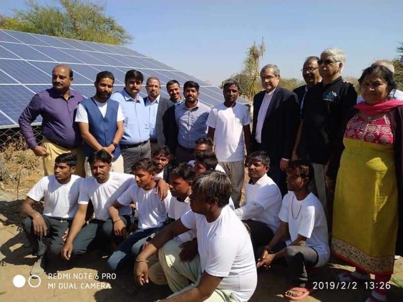 Dr. Camillus with group in front of solar panels in Tuvar, India