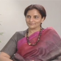 Ms. Preetha Reddy - Indian Woman sitting wearing pink and gray sarong