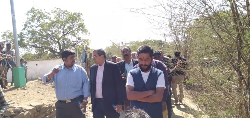 Dr. Camillus walking in village with group - Tuvar, India