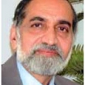 Mr. Kiran Karnik - Headshot of Indian man with gray beard and black hair in business suit
