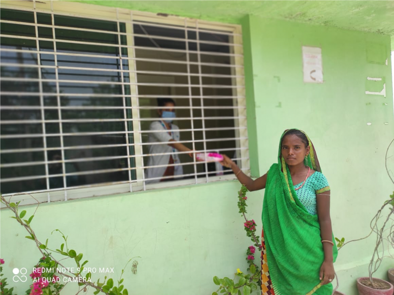 Woman in green sarong at window - SHE program