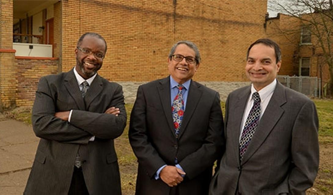 three people standing in front of a building